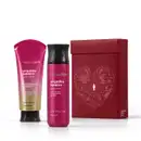 Caixa de presente de cor vinho com um grande coração ilustrado detalhes de temática celestial. Ao lado, itens de perfumaria da marca Nativa SPA Orquídea Lumière, sendo uma bisnaga de creme corporal perfumado e body spray, ambos cor-de-rosa com tampa preta