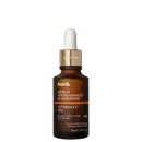 Frasco de vidro marrom com conta-gotas e rótulo dourado contendo "Botik Sérum Antioxidante Iluminador Vitamina C 10%". Produto promete recuperar a luminosidade na primeira aplicação.