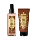 Eudora Instance Âmbar Precioso: Body Splash 200ml com frasco spray transparente e Creme Hidratante 150ml em tubo marrom. Embalagens com detalhes dourados e padrão ornamental. Produtos da linha Joias do Oriente.