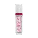 Frasco cilíndrico de vidro transparente com tampa branca tipo pump e tampa protetora. Produto rosa claro contendo pequenos pontos vermelhos. Rótulo transparente em em letras brancas e rosa pink.