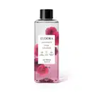 O produto apresentado é um óleo bifásico corporal da linha Instance Rosa Absoluta. O frasco é transparente, com um rótulo branco contendo o nome da marca, da linha e do aroma. A embalagem possui uma tampa preta e contém 200 ml do produto.
