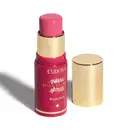 O produto apresentado é um blush stick da linha Niina Secrets da marca Eudora. Possui uma embalagem rosa com detalhes dourados, incluindo o nome da marca e da linha. O produto tem formato cilíndrico e tampa dourada.