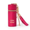 Acessório Porta Batom da marca Niina Secrets, em formato cilíndrico, com tampa rosada e detalhes dourados, com texto impresso "Niina Secrets" em dourado. Com pingente em forma de chave dourado.