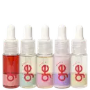 Cinco frascos com contagotas de GE Beauty em cores variadas: vermelho, bege, rosa claro, roxo e amarelo claro. Embalagens transparentes com rótulos vermelhos e tampas brancas arredondadas.