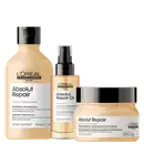 A imagem mostra 3 produtos da linha Absolut Repair da L'Oréal. O primeiro é um shampoo em uma embalagem plástica bege de 300ml. O segundo é um óleo em um frasco plástico bege com aplicador spray. O terceiro é um máscara em um pote plástico bege de 250g.