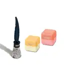 Três produtos da marca Quem Disse, Berenice?: um frasco de delineador líquido prata e dois hidratantes labiais em formato de caixinha.