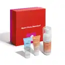 Caixa vermelha e rosa contendo três produtos Skin.Q: um hidratante, um esfoliante e uma espuma de limpeza, todos em embalagens brancas com rótulos e informações sobre os produtos.