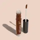 Frasco cilíndrico transparente contendo um gloss labial marrom. Rótulo na embalagem com o nome do produto "Gloss dos Sonhos" e a descrição "Quem disse, berence?". Ao lado, a tampa preta do produto, que acompanha um aplicador de espuma.