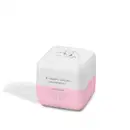 Produto de beleza em formato cúbico com tampa arredondada. Embalagem branca com detalhes em rosa claro. Apresenta um desenho estilizado de uma vaca na parte superior branca. A embalagem tem um design minimalista, com poucas cores e elementos simples.