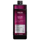 Frasco de item de perfumaria preto e rosa com rótulo "TRUSS PROFESSIONAL COLOR SHIELD". O frasco possui formato cilíndrico com tampa preta. O rótulo apresenta o nome da marca em letras brancas e informações sobre o produto em texto rosa e branco.