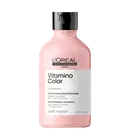 Frasco de plástico rosa com tampa preta. Rótulo com texto "L'OREAL PROFESSIONNEL PARIS Vitamino Color" e "SHAMPOOING PROFESSIONNEL". Produto de cuidados capilares para cabelos coloridos.