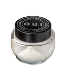 Frasco de vidro transparente com tampa preta redonda contendo produto da marca O.U.i. O rótulo preto destaca o nome da marca e a declaração "Unique Original Indulgent" em letras brancas.