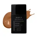 Frasco de base líquida na cor 270 da marca Make B. Mate Salicylic em embalagem preta com rótulo cinza, à frente de amostra de produto bege escuro.