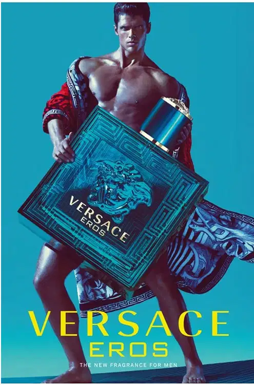A imagem mostra um cartaz com a propaganda da Versace, com um homem segurando o perfume Eros. Na parte inferior do cartaz, a marca e o nome do perfume estão escritos em amarelo.