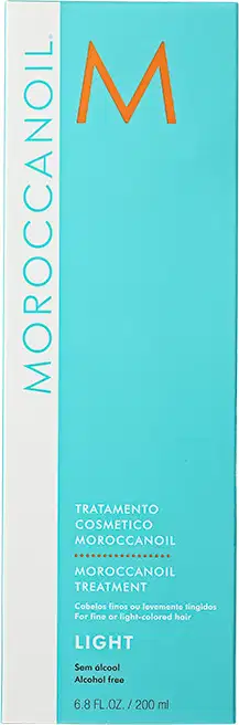 A imagem mostra a caixa do produtos Moroccanoil Treatment Light. Embalagem retangular de cor azul clara e branca. Logotipo laranja "M" em destaque.
