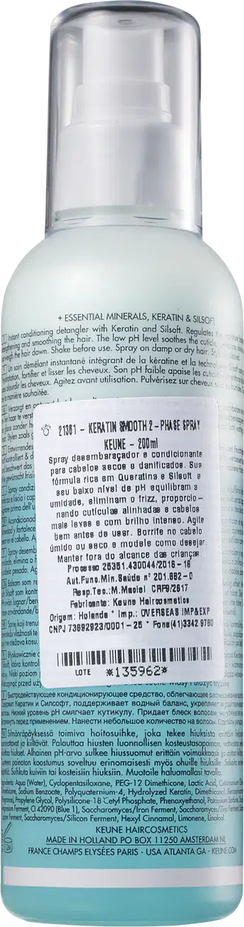 Frasco de spray de cabelo Keune com fórmula de queratina e silício, embalagem transparente com rótulo branco e azul, contendo informações sobre o produto.