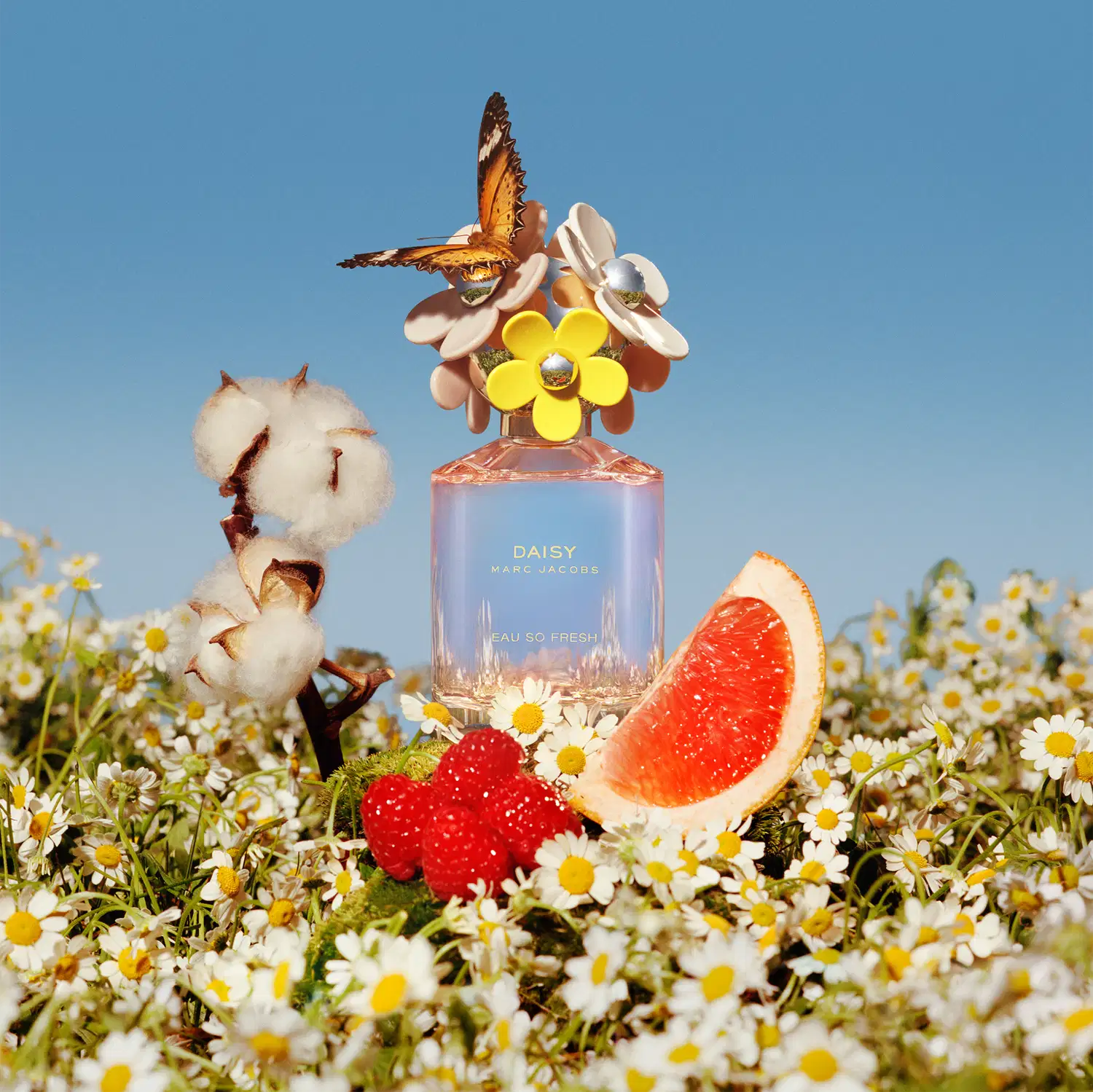 Frasco de perfume Daisy Marc Jacobs Eau So Fresh, com tampa decorada com flores coloridas em tons de rosa, amarelo e branco, em fundo branco.