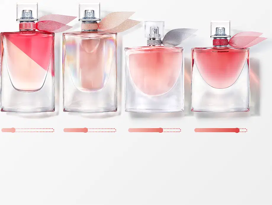 Quatro frascos de perfume Lancôme em diferentes tamanhos, com tonalidades rosadas e detalhes prateados na embalagem. Os produtos apresentam design elegante e sofisticado, com rótulos e tampas que sugerem fragrâncias delicadas e femininas.