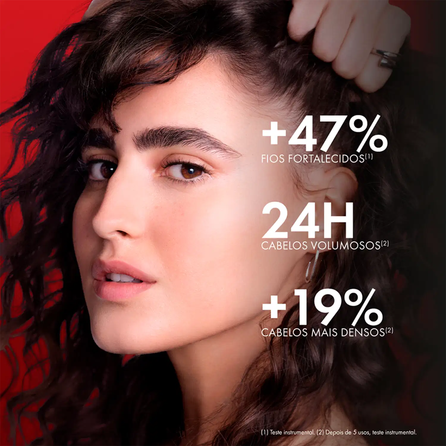 Imagem de uma mulher com cabelos escuros e ondulados, com texto "+47% fios fortalecidos, 24h cabelos volumosos, +19% cabelos mais densos" sobre sua face.