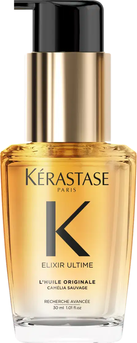 A imagem mostra o óleo capilar da marca Kérastase. O frasco é transparente, permitindo ver o líquido dourado dentro. O frasco tem um formato cilíndrico e uma bomba dosadora preta no topo. O rótulo apresenta letras pretas sobre um fundo dourado.