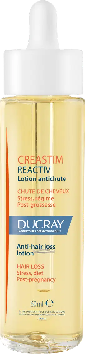 A imagem mostra um frasco transparente contendo um líquido amarelo claro. É o "Creastim Reactiv", da marca Ducray. Trata-se de uma loção antiqueda de cabelo. O frasco tem um aplicador em formato de conta-gotas na parte superior e 60ml de produto.