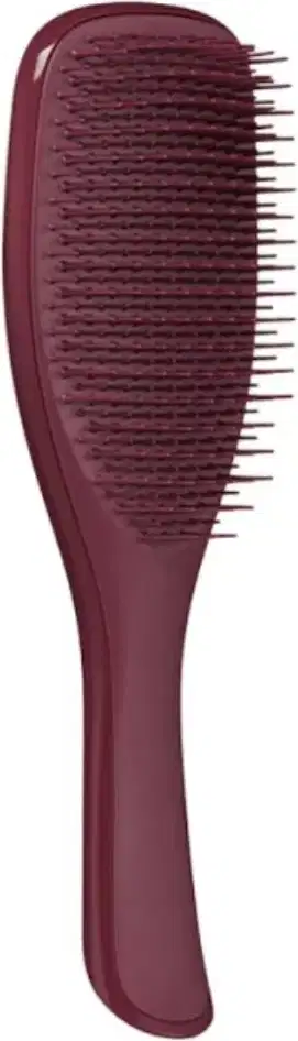A imagem mostra uma escova de cabelo na cor vinho, com corpo plástico alongado com formato ergonômico, compacto e portátil e cerdas também de plástico.