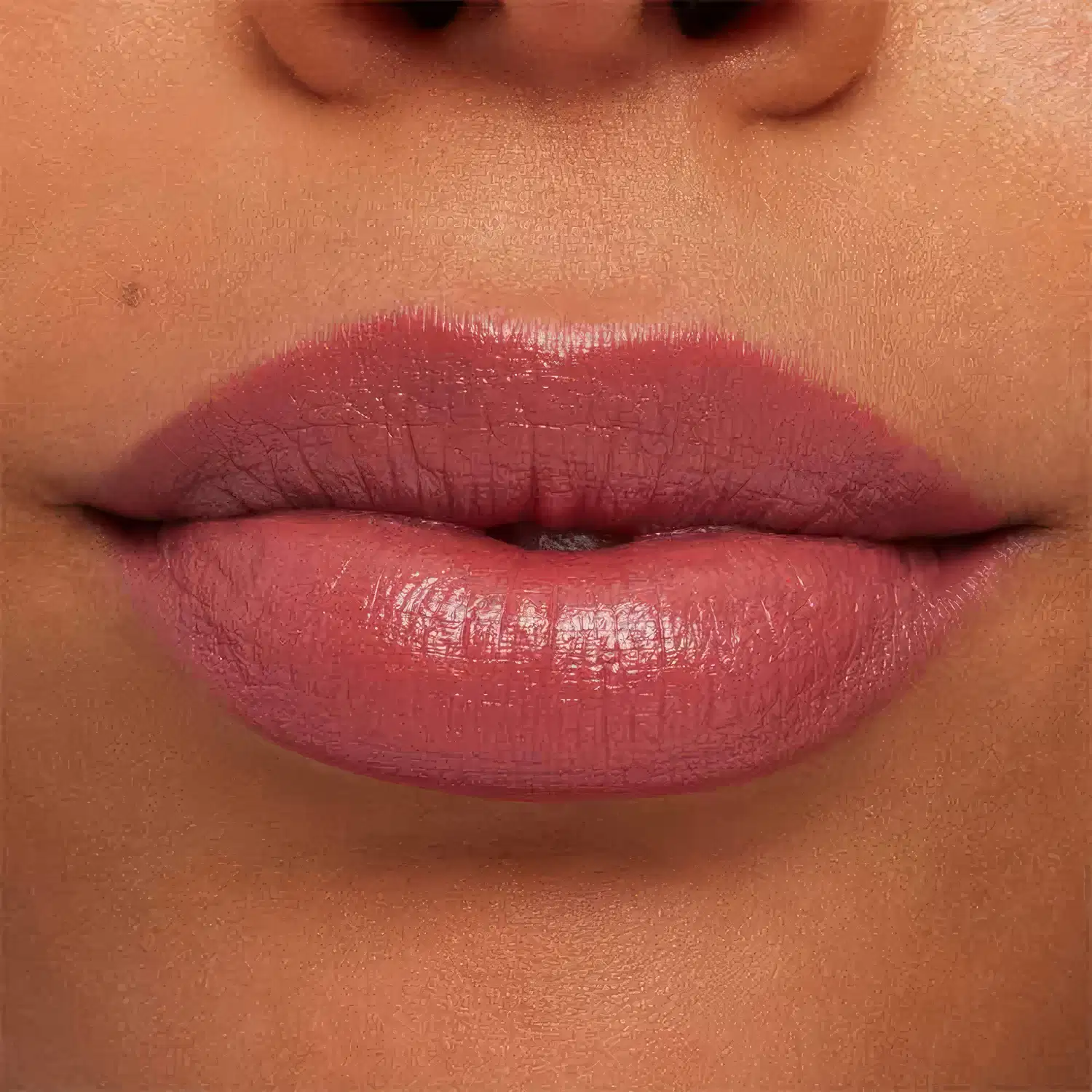 A imagem mostra a boca de uma mulher usando o batom.