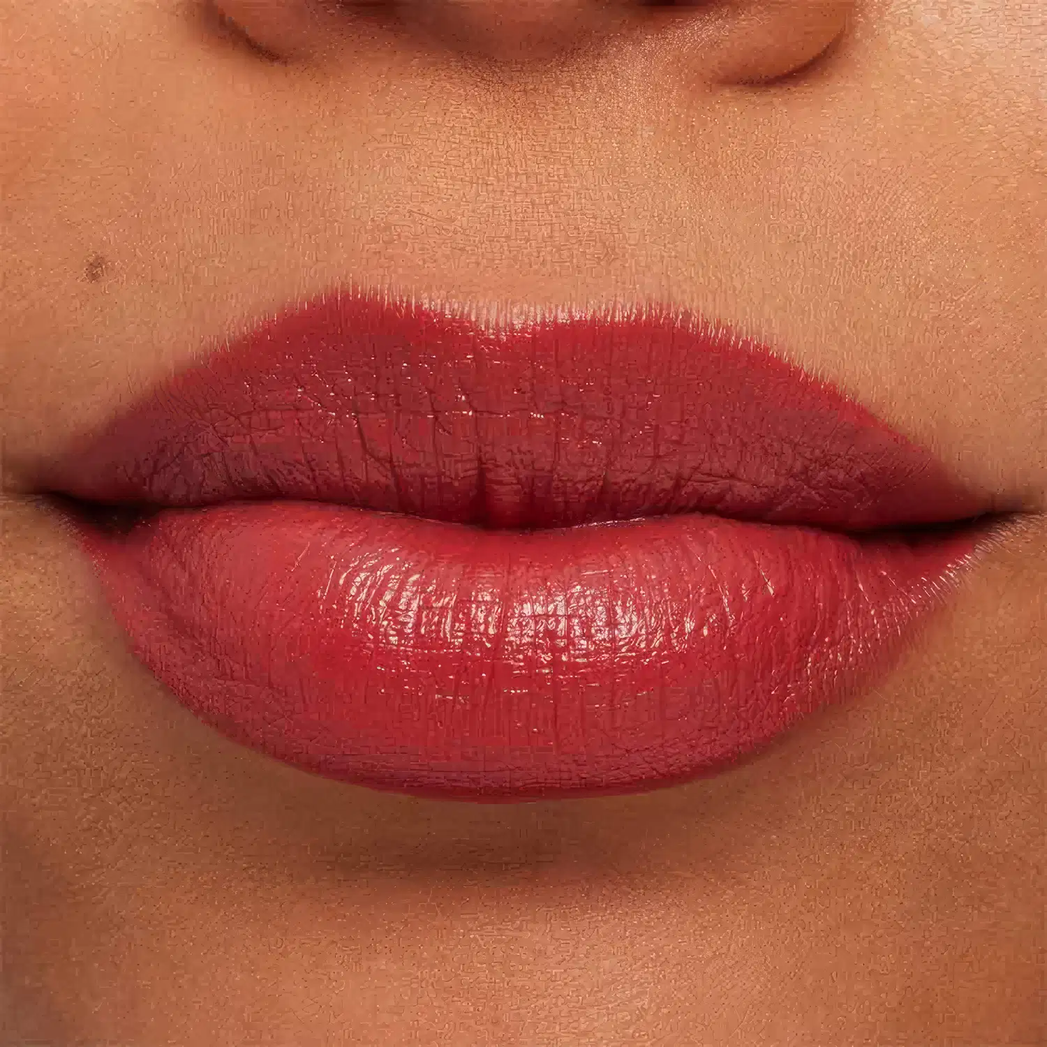 A imagem mostra a boca de uma mulher usando o batom.