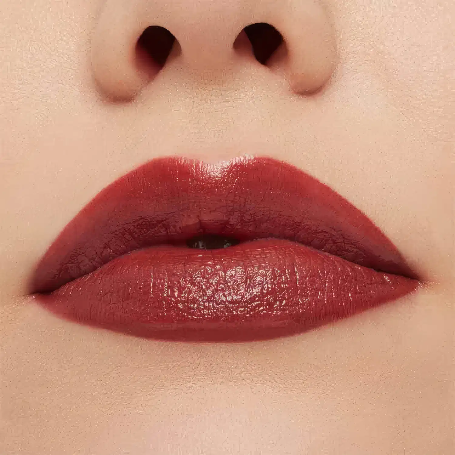 A imagem mostra a boca de uma mulher usando o batom.
