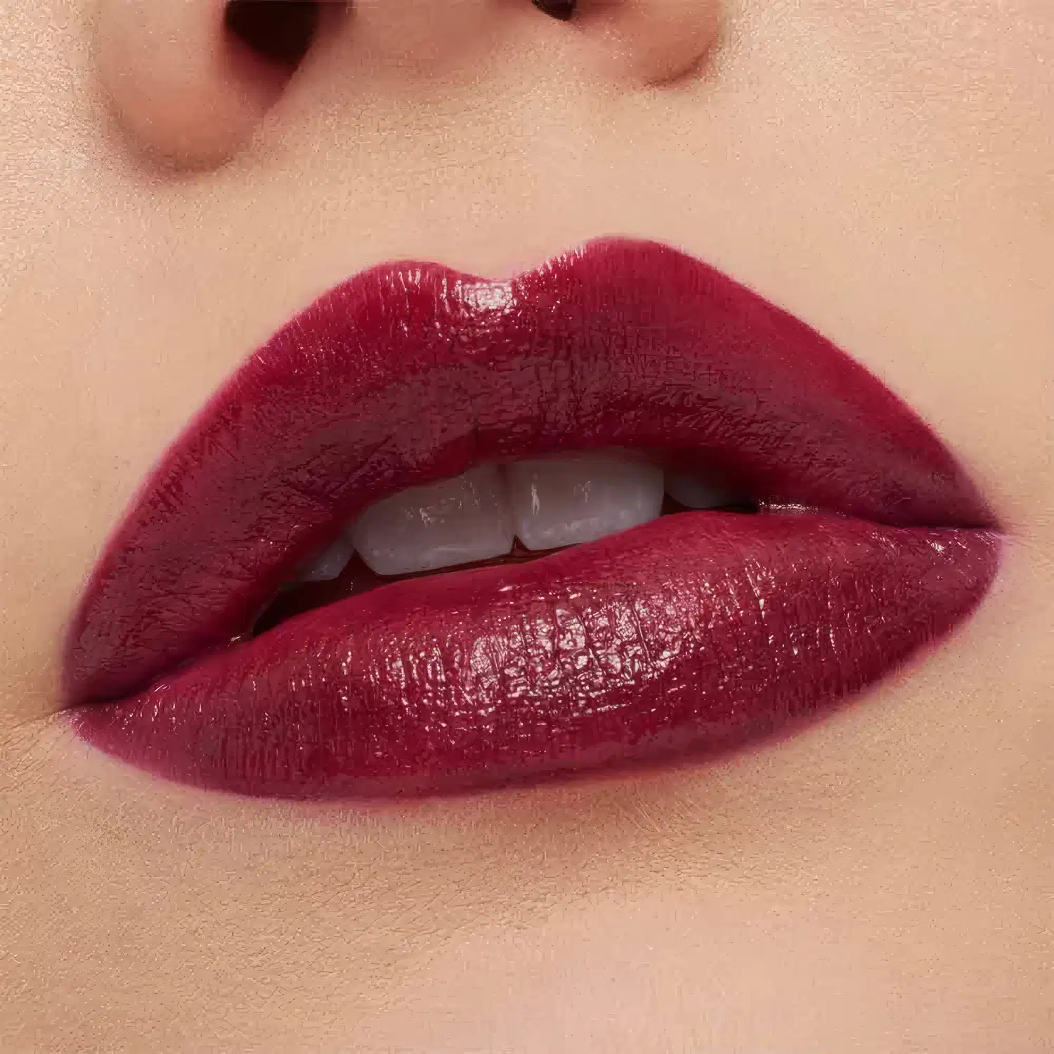 A imagem mostra a boca de uma mulher usando o batom.