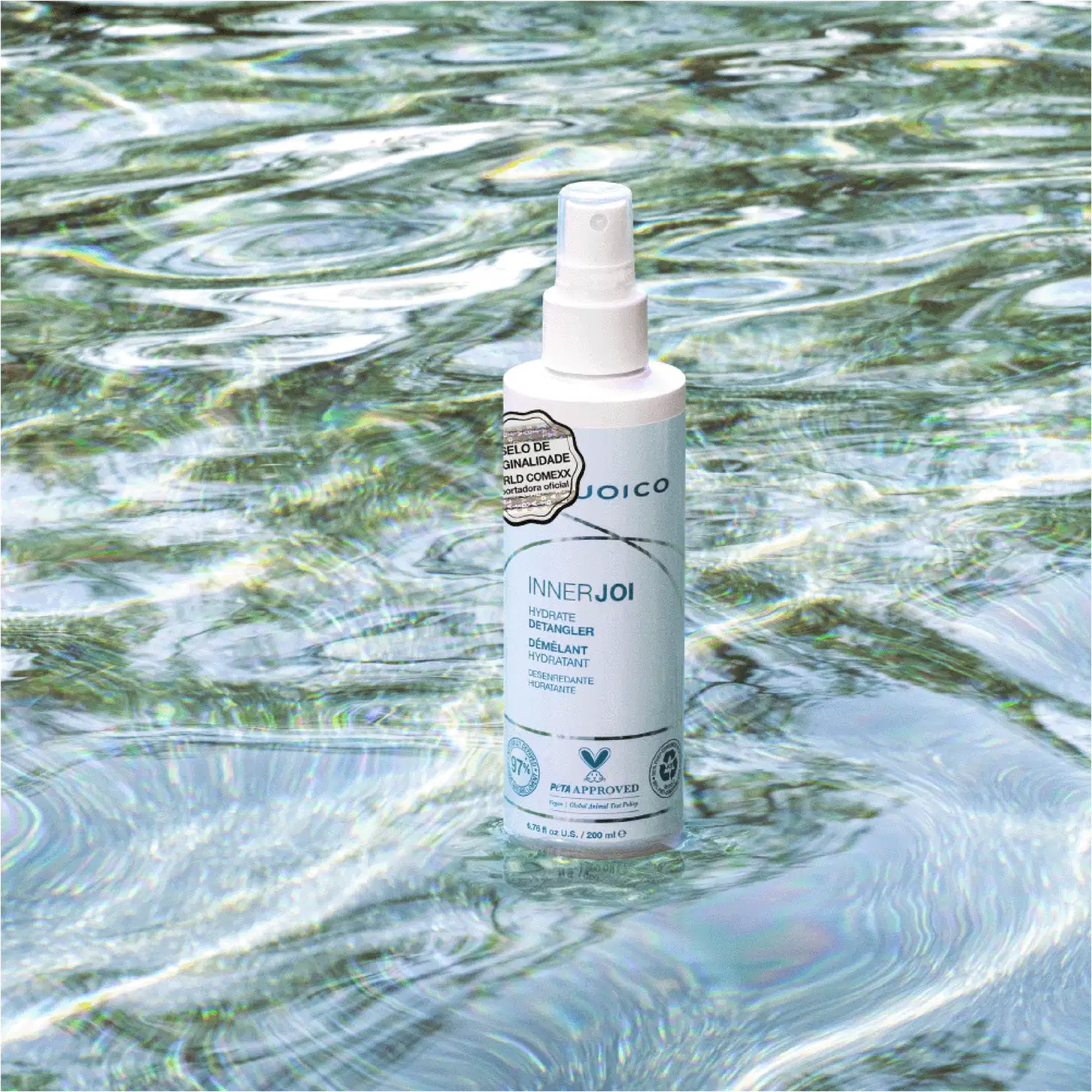 O Leave-in Joico InnerJoi Hydrate Detangler (200ml), em sua embalagem verde com detalhes em branco, se destaca em um fundo que lembra água cristalina, transmitindo uma sensação de leveza e frescor