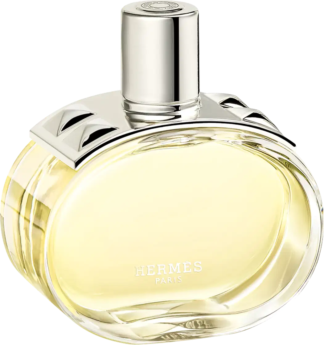 A imagem mostra o perfume Barénia de Hermès. Seu frasco é de vidro arredondado e transparente, permitindo ver o líquido amarelado em seu interior. Sua tampa é cilíndrica e prateada e possui uma aplicação com pinos em forma de pirâmide com facetas curvas.