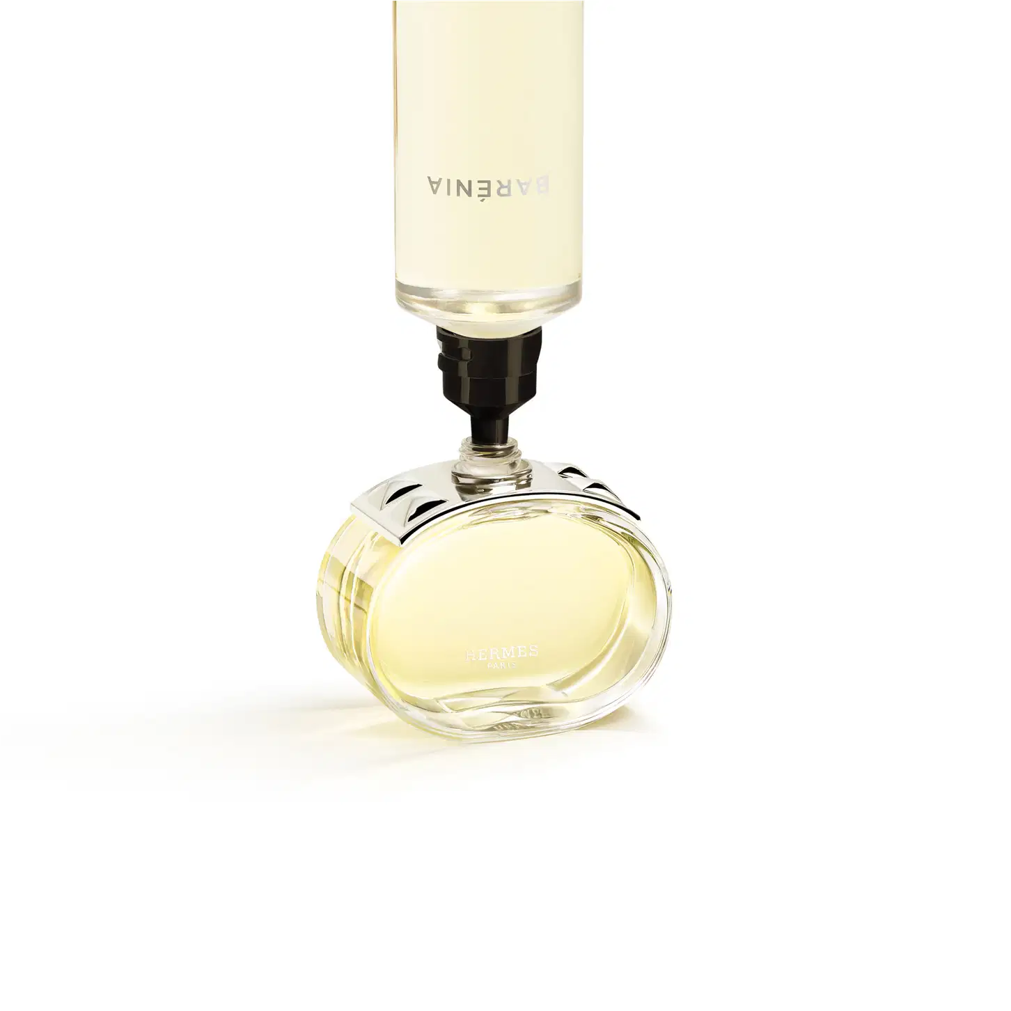 Perfume em frasco de vidro transparente com detalhes cromados sendo preenchido pelo seu refil.