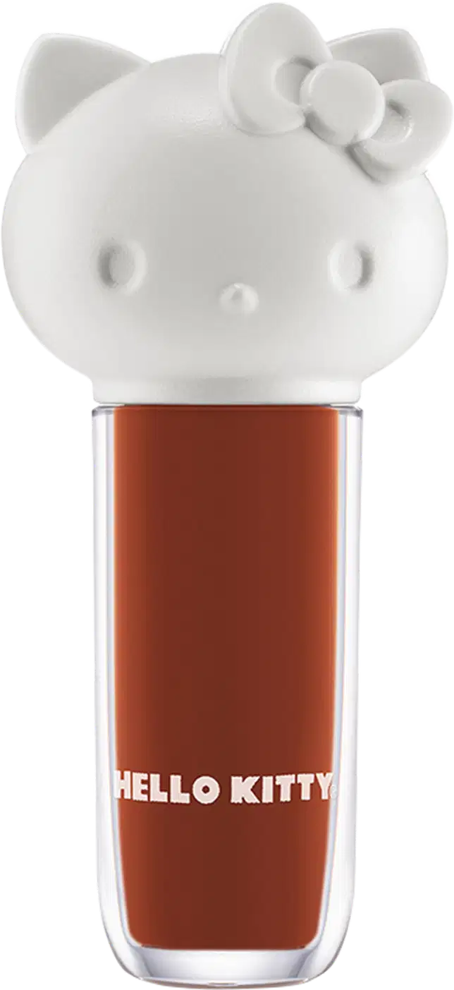 Maquiagem em formato cilíndrico com a cabeça da personagem Hello Kitty como tampa. A parte superior é branca com detalhes em relevo que representam os olhos, orelhas e laço da Hello Kitty. É possível ver a cor do produto pelo corpo transparente.