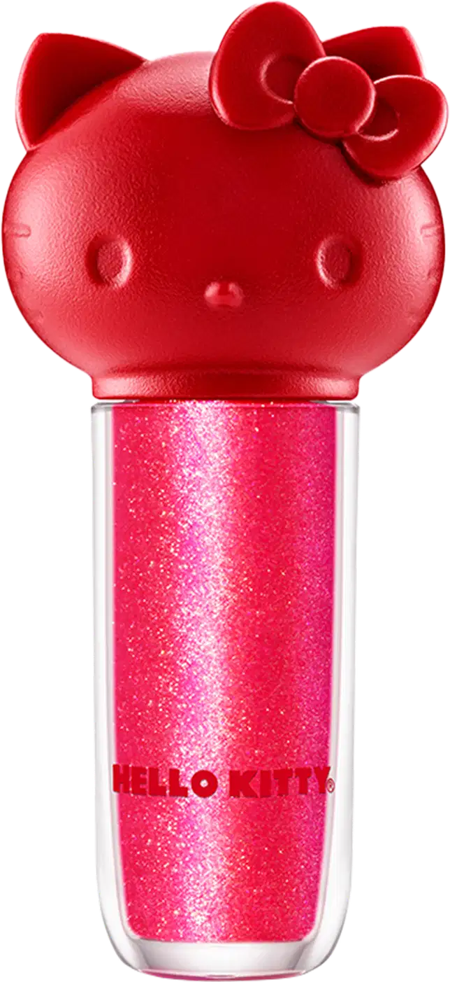 Maquiagem em formato cilíndrico com a cabeça da personagem Hello Kitty como tampa. A parte superior é vermelha com detalhes em relevo que representam os olhos, orelhas e laço da Hello Kitty. É possível ver a cor do produto pelo corpo transparente.