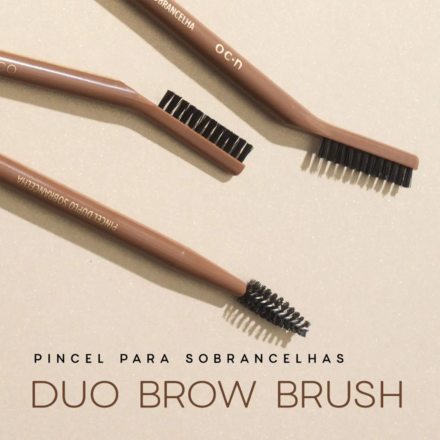 Pincel para sobrancelhas da marca Océane, com duas escovas em tons de marrom. O produto é chamado de "Duo Brow Brush" e possui embalagem com texto em português.