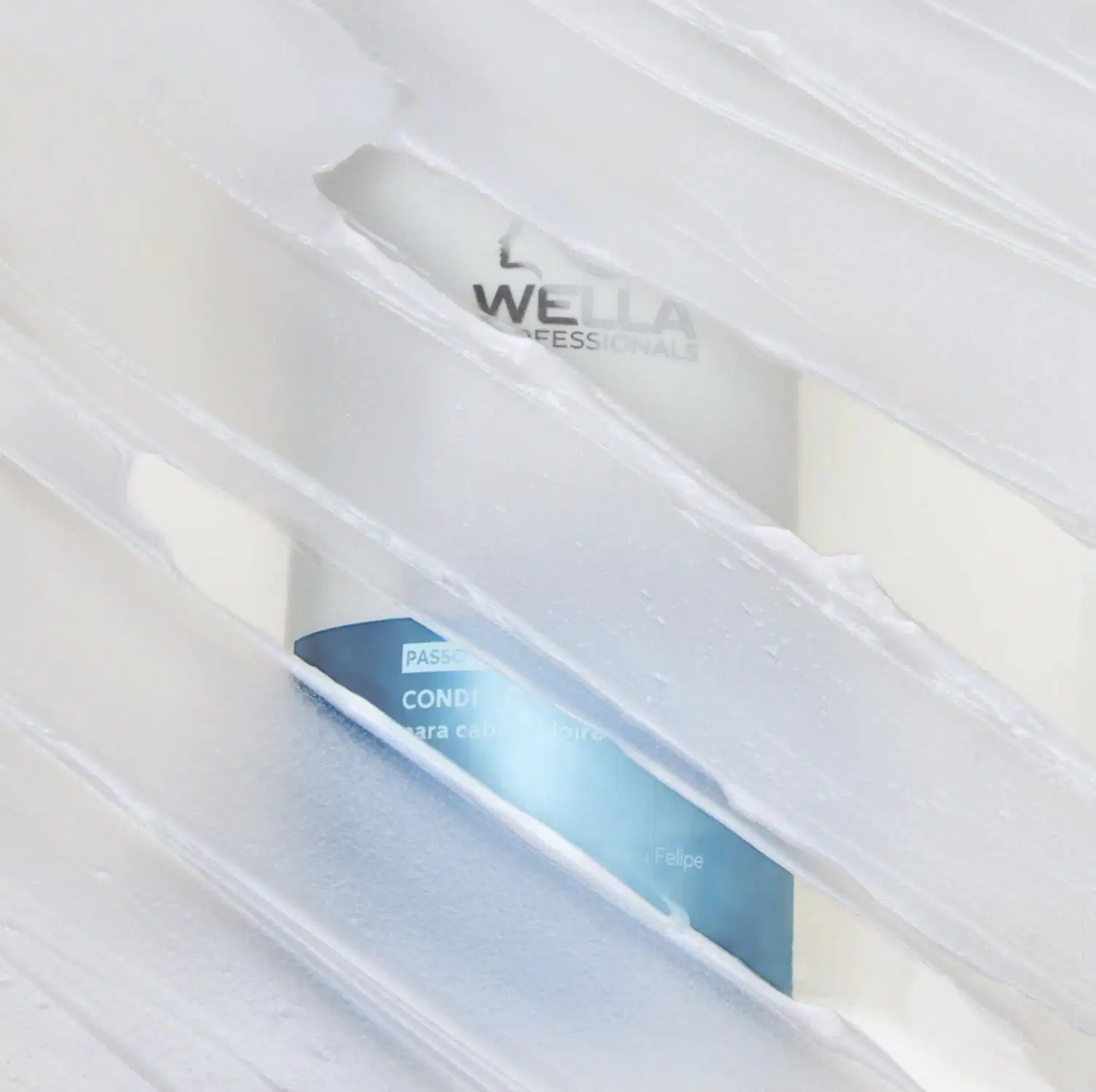 Embalagem de produto da marca Wella Professionals, com frasco de condicionador em fundo branco translúcido, sugerindo um ambiente de cuidados capilares profissionais.