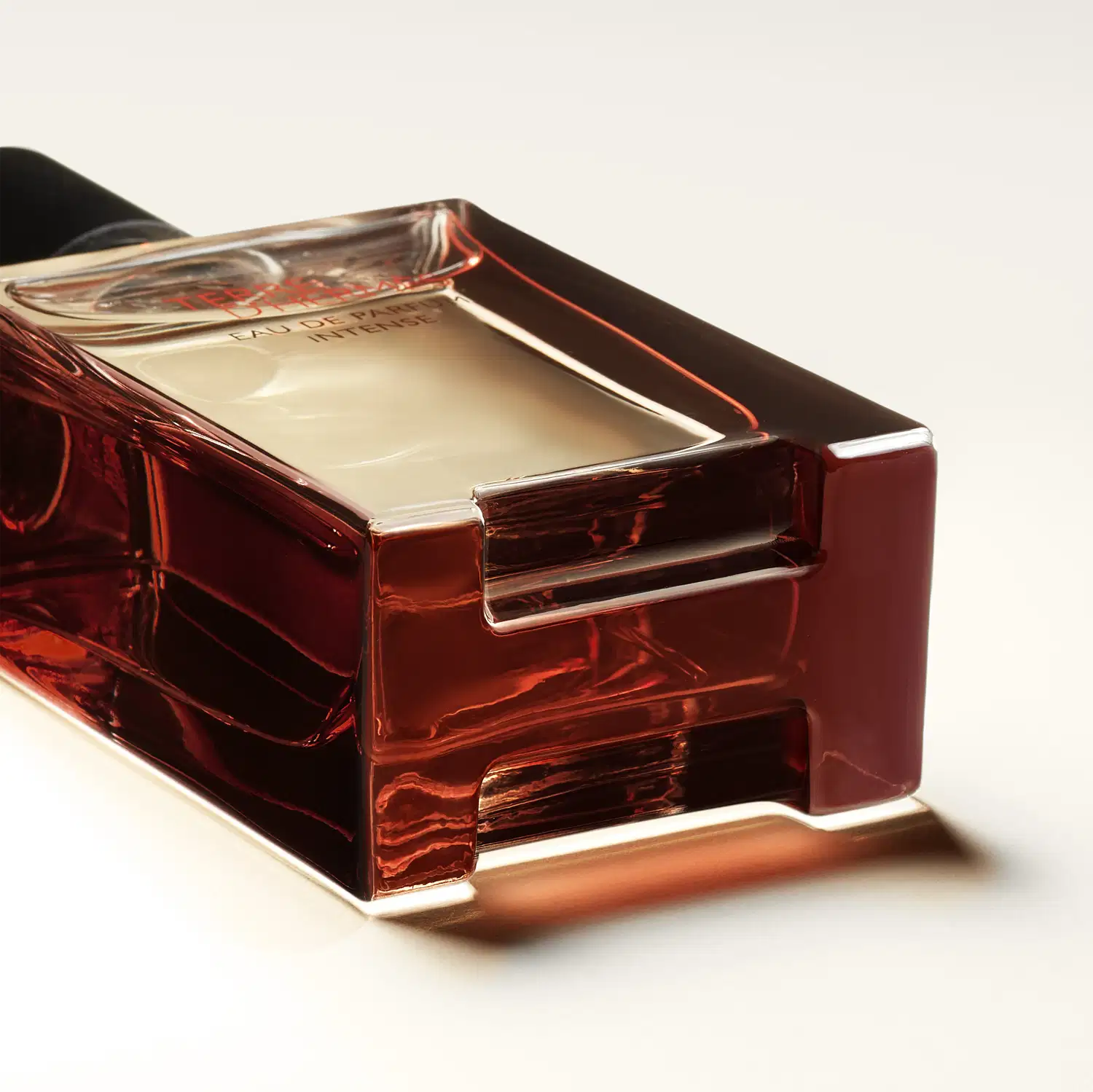 Frasco de perfume Terre d'Hermès Eau de Parfum Intense, com embalagem de vidro transparente e tampa preta. Rótulo em vermelho com o nome da fragrância em destaque.