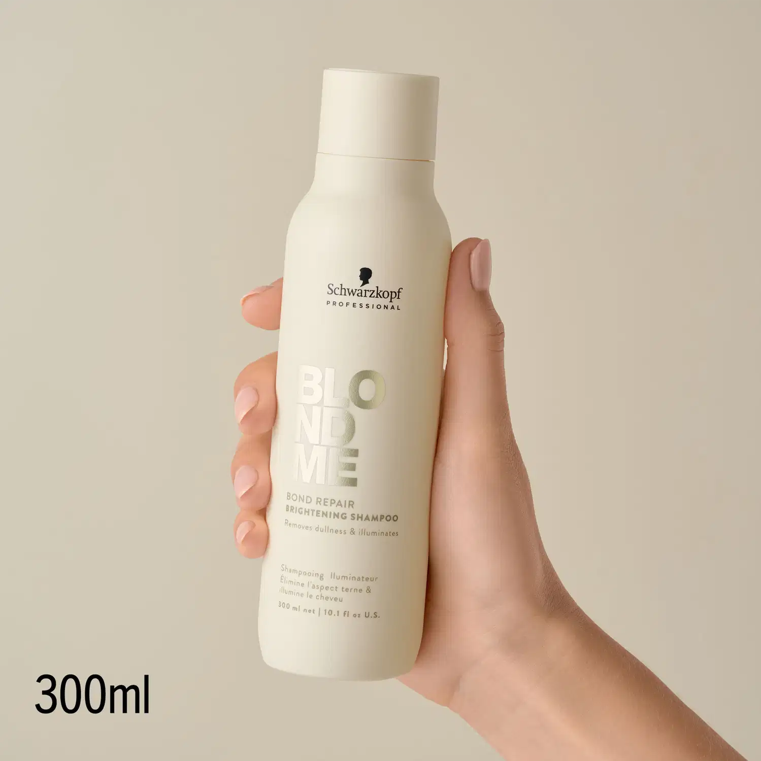 Produto de cabelo da marca Schwarzkopf Professional, em embalagem branca com detalhes em tons de cinza, em mãos femininas com unhas pintadas, em ambiente claro e neutro.