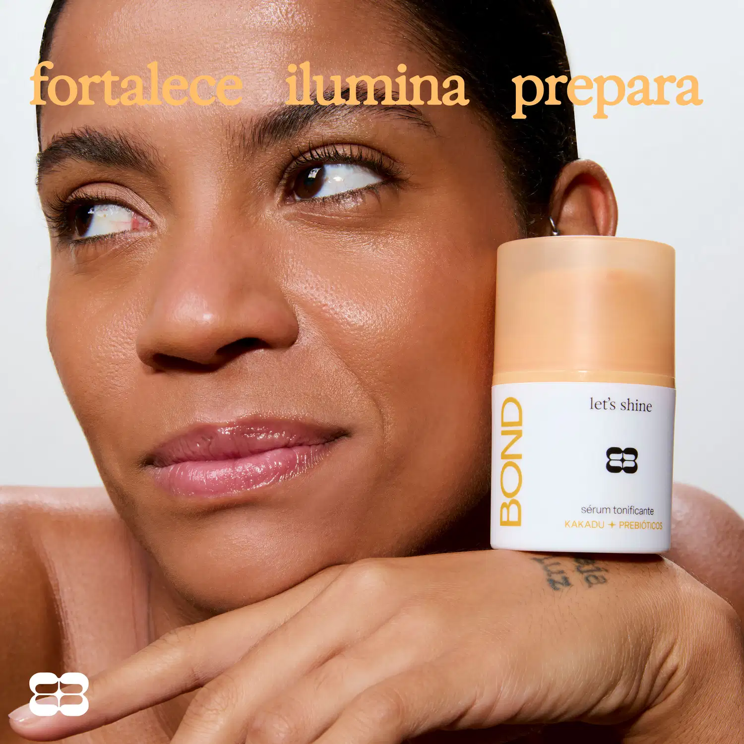 Rosto de uma mulher com maquiagem, com texto "fortalece ilumina prepara" e embalagem de item de perfumaria da marca Bond Rio com texto "let's shine" e "sérum tonificante".