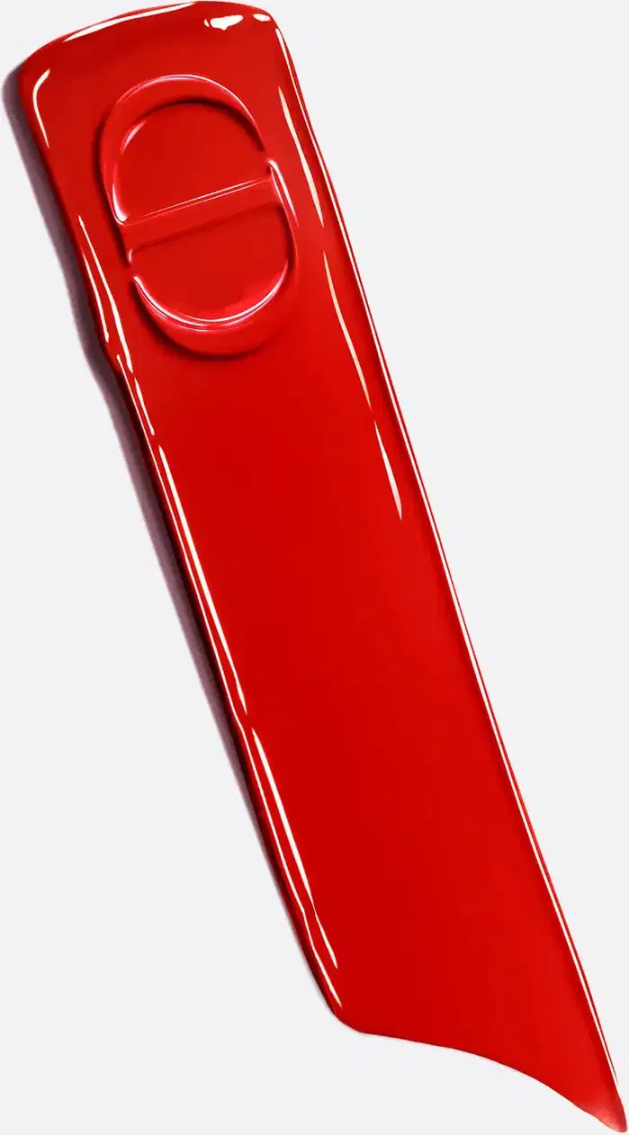 Textura brilhante e lisa com acabamento lacado. Superfície vermelha intensa com reflexos luminosos. Consistência dura e polida, característica de produtos de luxo Dior com aplicador ergonômico integrado.