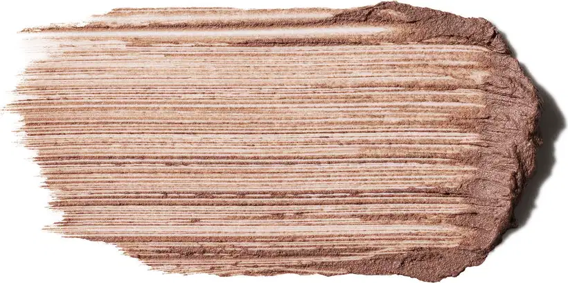 Textura cremosa com acabamento mate e linhas horizontais marcadas. Tons de bege e marrom claro predominam. Consistência densa e pigmentada, com superfície levemente granulada e efeito de pó compactado, típico de produtos de base ou contorno.