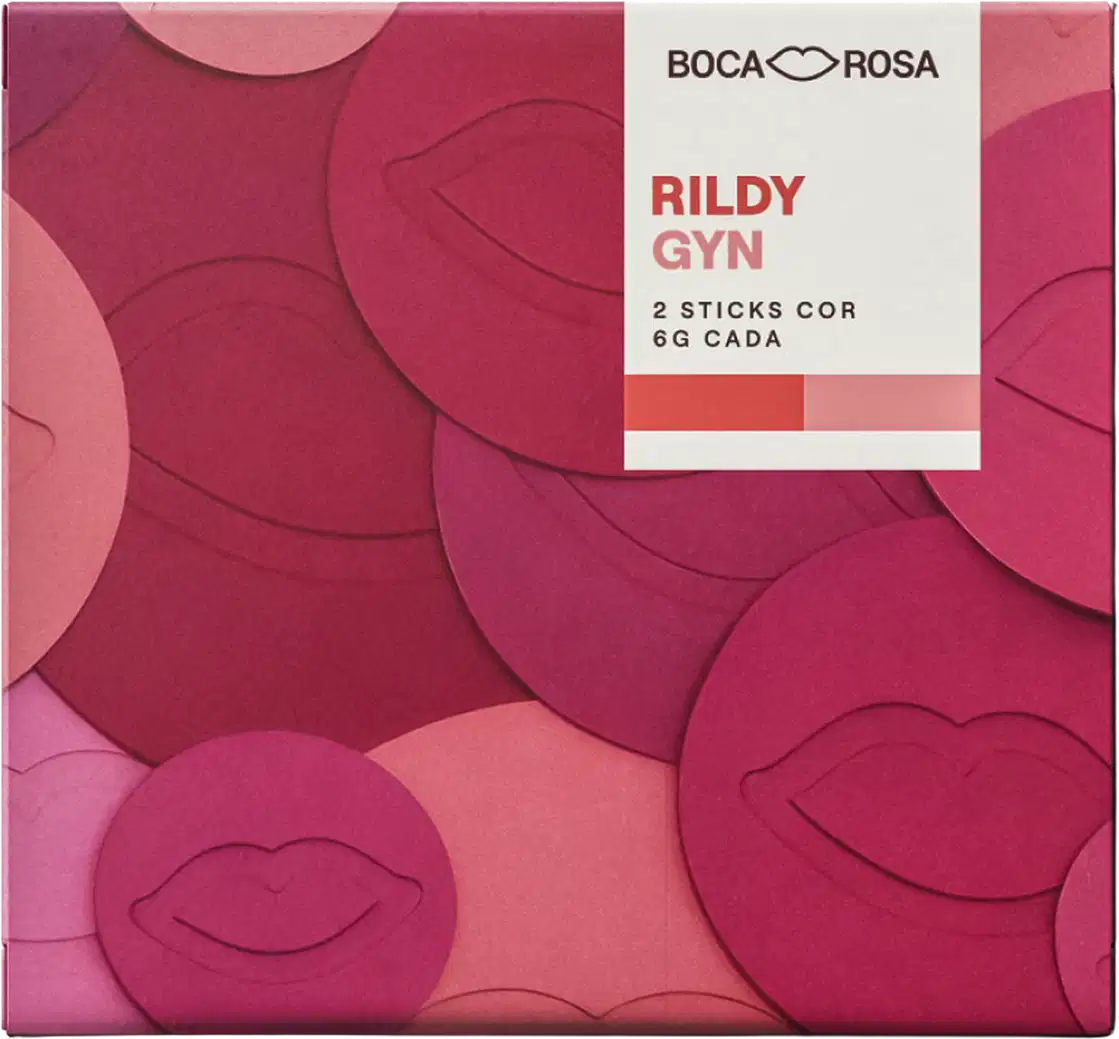 Embalagem Boca Rosa Rildy Gyn com 2 sticks cor rosa e vermelho, caixa quadrada em tons de rosa e vermelho com padrão de lábios em relevo.