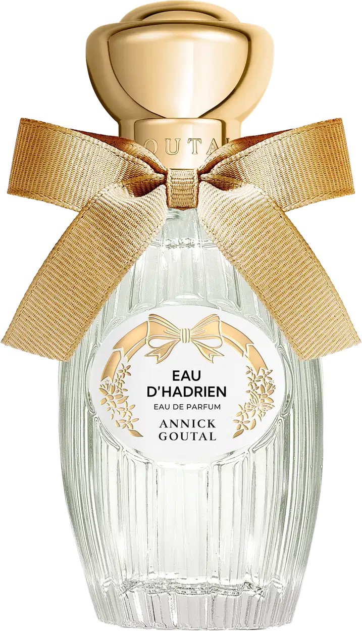 Eau de Parfum Eau d'Hadrien da Annick Goutal em frasco de cristal estriado com tampa dourada em formato de esfera. Decorado com laço de fita bege e rótulo circular branco com detalhes florais dourados.