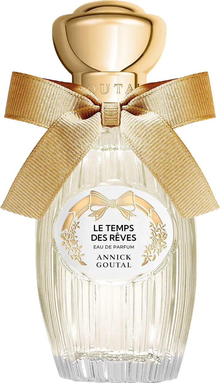 Eau de Parfum "Le Temps des Rêves" Annick Goutal em frasco de cristal transparente com tampa dourada esférica, laço de fita bege e rótulo circular branco com detalhes florais dourados.