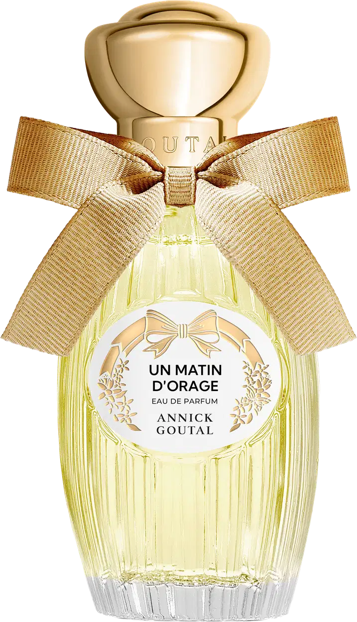 Eau de Parfum Un Matin d'Orage da Annick Goutal em frasco de vidro amarelo claro com tampa dourada esférica, decorado com laço de fita bege e rótulo circular branco com detalhes florais dourados.