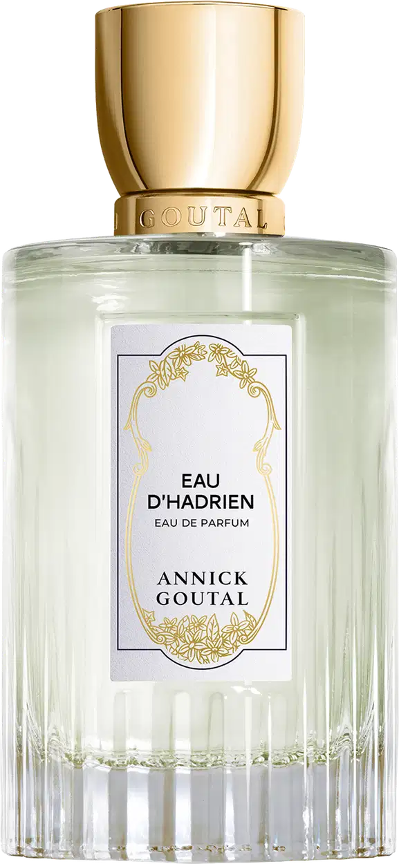 Eau de Parfum Eau d'Hadrien da Annick Goutal em frasco cilíndrico de vidro transparente com líquido incolor. Tampa dourada cilíndrica. Rótulo branco com ornamentação dourada e texto em preto.
