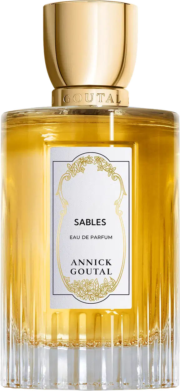 Eau de Parfum Sables da Annick Goutal em frasco cilíndrico de vidro com líquido amarelo dourado. Tampa dourada polida. Rótulo branco com ornamentação dourada e texto em preto. Base estriada em vidro transparente.