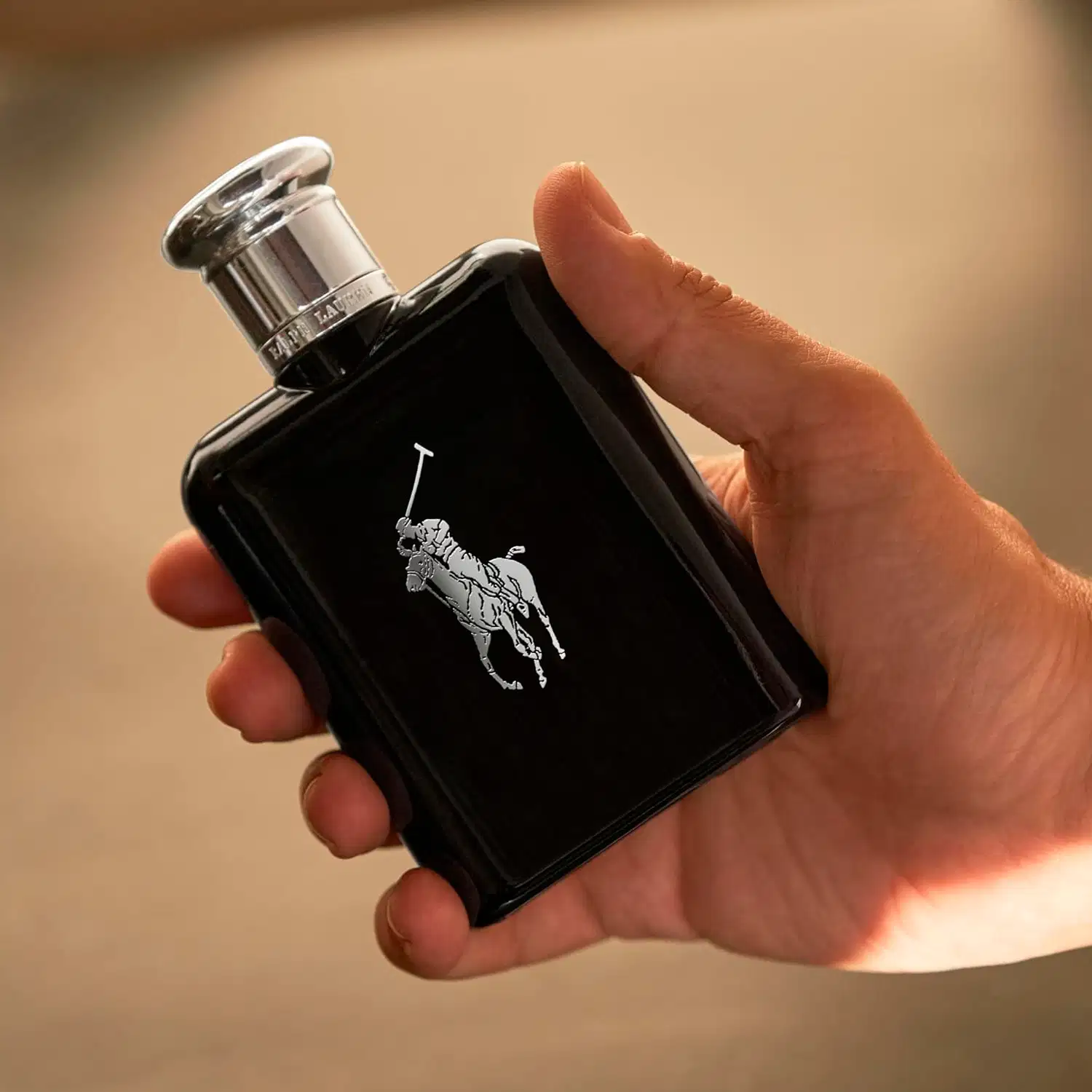 Frasco de perfume preto Polo Black da marca Ralph Lauren com tampa prateada e logotipo da marca em destaque.