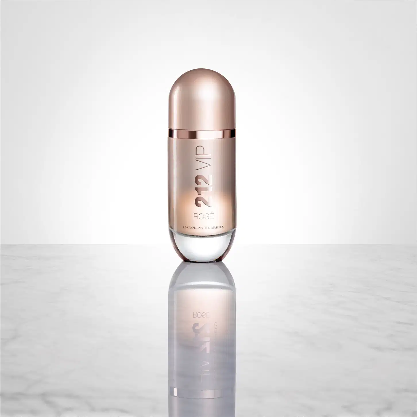 Frasco de perfume Carolina Herrera 212 VIP, com design elegante e minimalista em tons rosados, destacando o nome da marca e a numeração do produto.